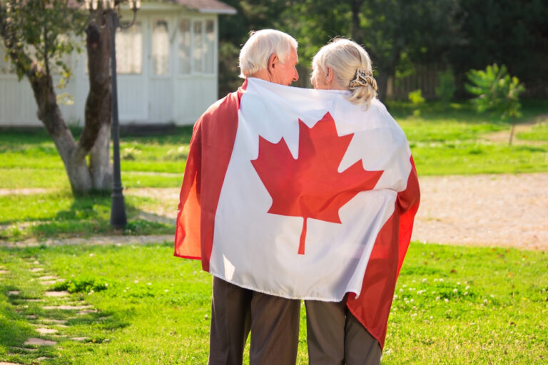 Senior,Couple,And,Canadian,Flag.,Two,Elderly,People,,Back,View.